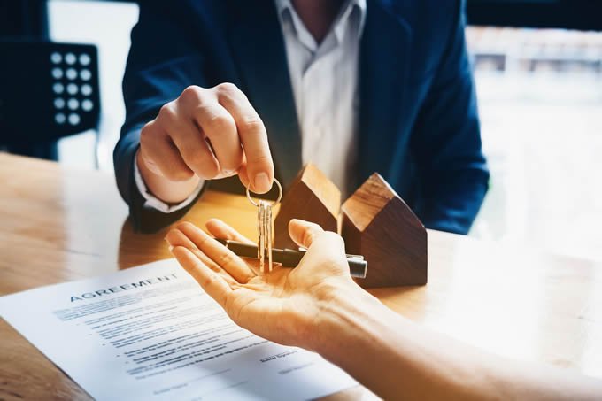 Real estate closing documents and keys representing a closed motivated seller transaction